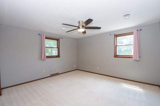 1618 10th St N, Fargo, ND 58102 - empty room featuring plenty of natural light, light colored carpet, a ceiling fan, and baseboards