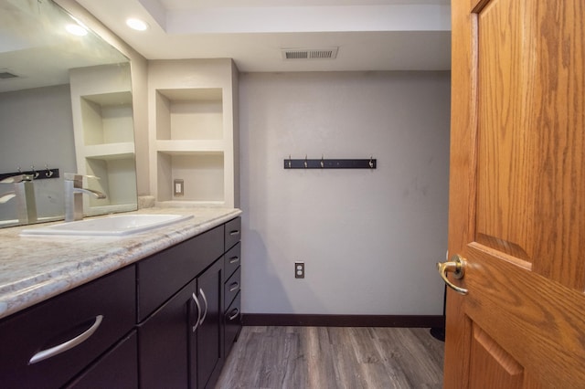1618 10th St N, Fargo, ND 58102 - bathroom featuring vanity, wood finished floors, built in shelves, and baseboards