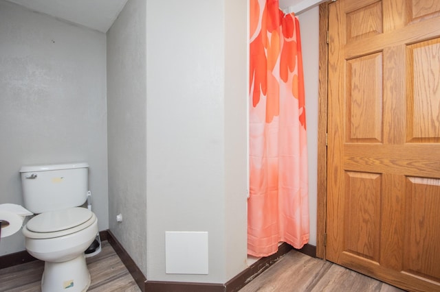 1618 10th St N, Fargo, ND 58102 - full bath featuring wood finished floors, toilet, curtained shower, and baseboards