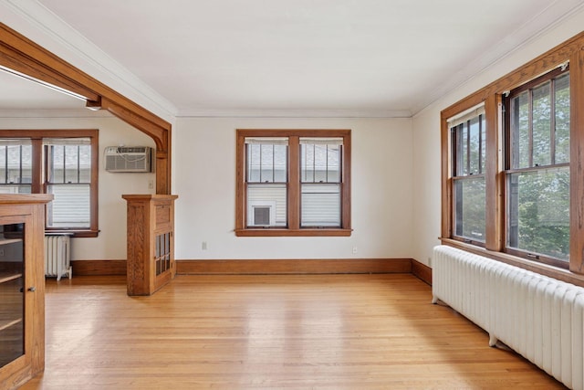 1601 Charles Ave, Saint Paul, MN 55104 - spare room featuring radiator, light wood finished floors, a wall unit AC, plenty of natural light, and crown molding