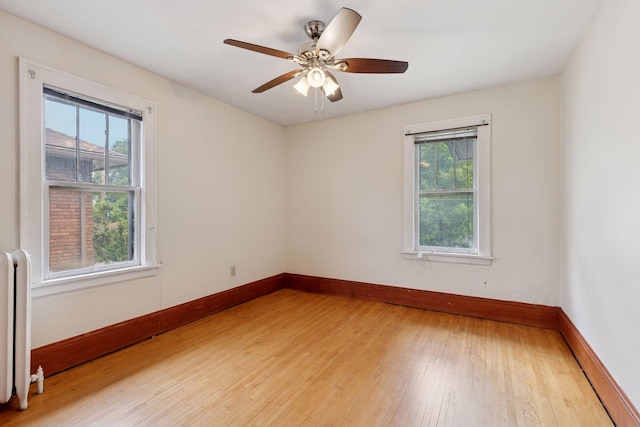 1601 Charles Ave, Saint Paul, MN 55104 - spare room featuring radiator heating unit, light wood-type flooring, and a ceiling fan