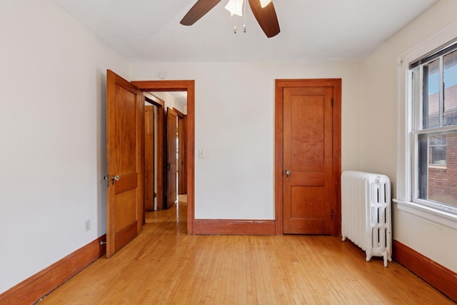 1601 Charles Ave, Saint Paul, MN 55104 - unfurnished bedroom featuring radiator, light wood finished floors, and a ceiling fan