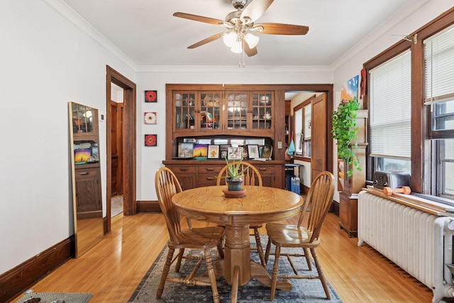1601 Charles Ave, Saint Paul, MN 55104 - dining area featuring radiator heating unit, ceiling fan, light wood finished floors, and crown molding