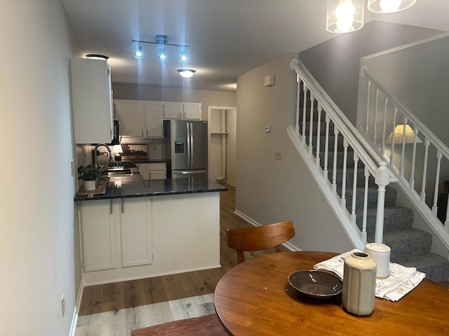 691 85th Ln NW Unit 1, Coon Rapids, MN 55433 - kitchen featuring stainless steel refrigerator with ice dispenser, dark countertops, dark wood-style floors, a peninsula, and a sink