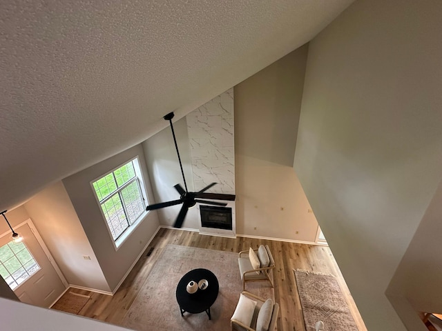 691 85th Ln NW Unit 1, Coon Rapids, MN 55433 - unfurnished living room with wood finished floors, a textured ceiling, baseboards, and lofted ceiling