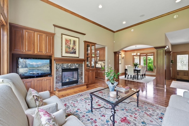 8867 Aviary Path, Inver Grove Heights, MN 55077 - living room featuring light wood-style floors, decorative columns, a chandelier, arched walkways, and crown molding