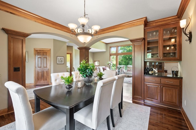 8867 Aviary Path, Inver Grove Heights, MN 55077 - dining space with arched walkways, ornate columns, crown molding, dark wood finished floors, and baseboards