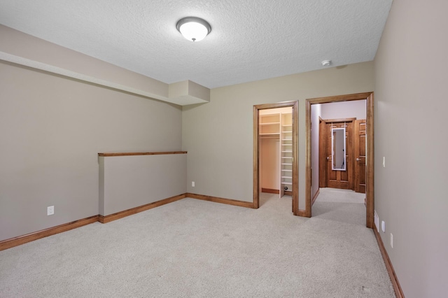 8867 Aviary Path, Inver Grove Heights, MN 55077 - unfurnished bedroom with light carpet, a textured ceiling, a walk in closet, baseboards, and a closet