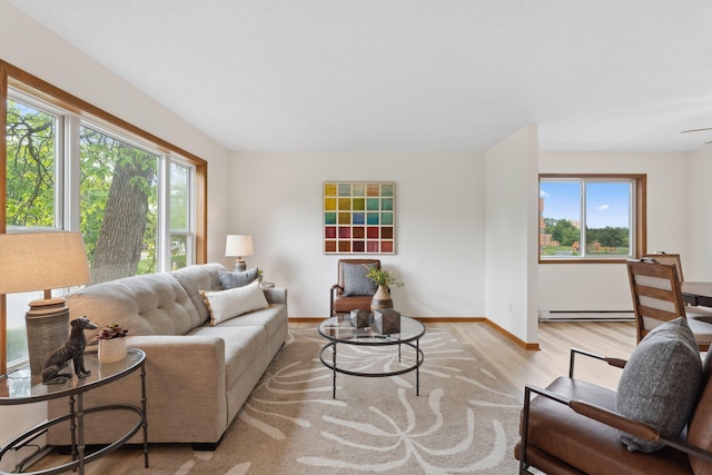2524 Bryant Ave N, Minneapolis, MN 55411 - living room featuring a baseboard radiator, healthy amount of natural light, wood finished floors, and baseboards