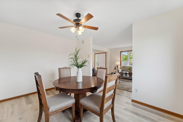 2524 Bryant Ave N, Minneapolis, MN 55411 - dining room featuring light wood-style flooring, ceiling fan, and baseboards