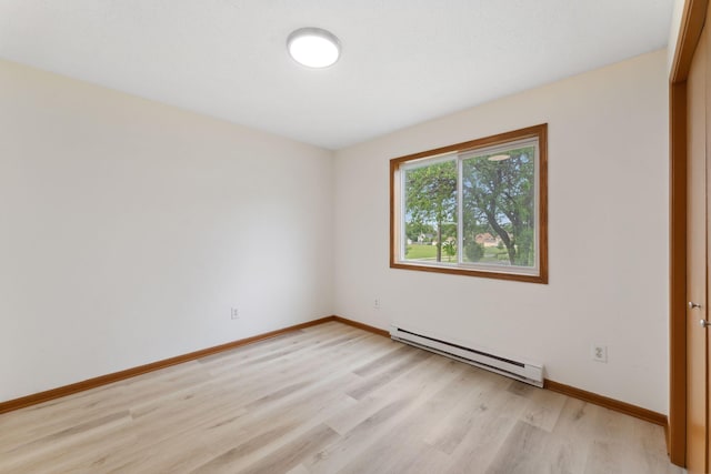 2524 Bryant Ave N, Minneapolis, MN 55411 - empty room featuring baseboard heating, light wood-style flooring, and baseboards
