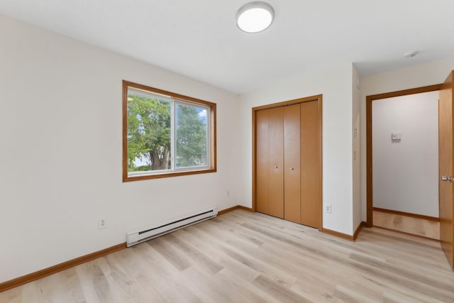 2524 Bryant Ave N, Minneapolis, MN 55411 - unfurnished bedroom with a baseboard radiator, light wood finished floors, a closet, and baseboards