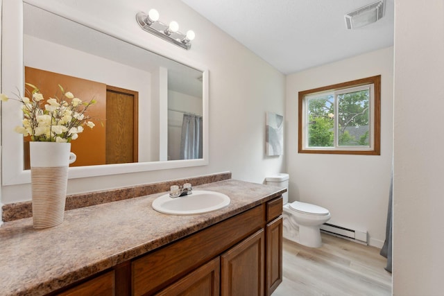 2524 Bryant Ave N, Minneapolis, MN 55411 - bathroom with a baseboard radiator, vanity, wood finished floors, and toilet