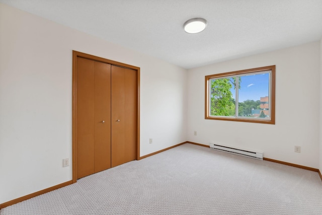 2524 Bryant Ave N, Minneapolis, MN 55411 - unfurnished bedroom with a baseboard heating unit, light carpet, a closet, and baseboards