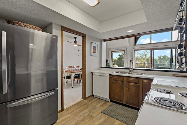 9700 Portland Ave S Unit 334, Bloomington, MN 55420 - kitchen with white appliances, light wood finished floors, light countertops, ceiling fan, and a raised ceiling