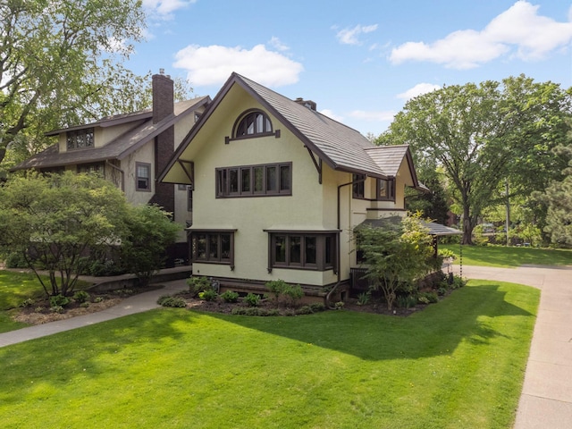 2022 Summit Ave, Saint Paul, MN 55105 - view of front facade featuring a chimney, a front lawn, and stucco siding