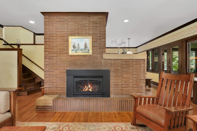 2022 Summit Ave, Saint Paul, MN 55105 - living room with wood finished floors, ornamental molding, a brick fireplace, stairway, and recessed lighting
