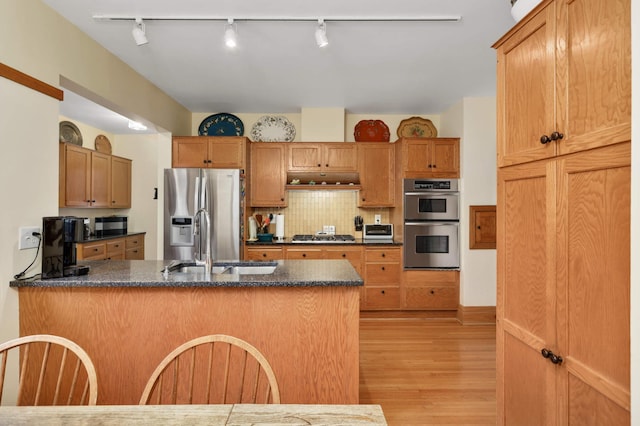2022 Summit Ave, Saint Paul, MN 55105 - kitchen with stainless steel appliances, track lighting, a sink, light wood-type flooring, and a peninsula