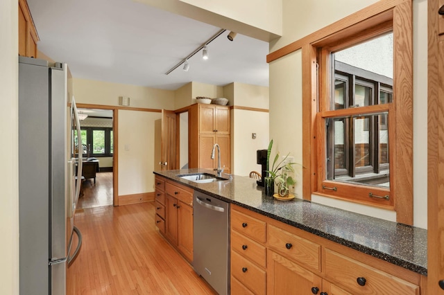 2022 Summit Ave, Saint Paul, MN 55105 - kitchen with a sink, stainless steel appliances, light wood-style flooring, track lighting, and dark stone counters