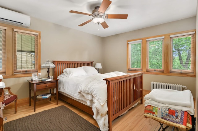 2022 Summit Ave, Saint Paul, MN 55105 - bedroom featuring radiator, a wall unit AC, wood finished floors, and a ceiling fan