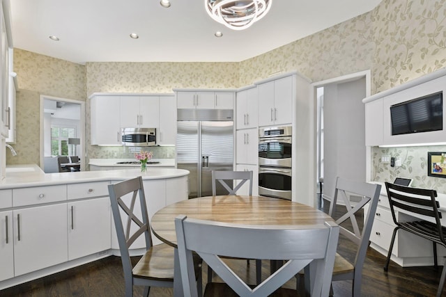 3490 Fairway Ln, Minnetonka, MN 55305 - kitchen featuring wallpapered walls, stainless steel appliances, dark wood-type flooring, light countertops, and white cabinetry