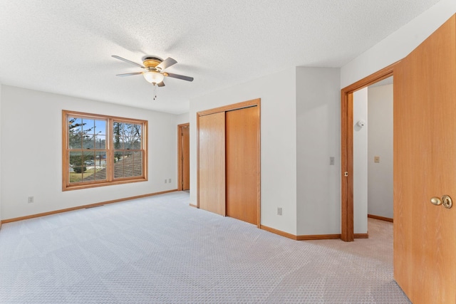 18504 Peach Tree Ct, Minnetonka, MN 55345 - unfurnished bedroom featuring a closet, light carpet, a textured ceiling, baseboards, and a ceiling fan