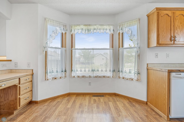 1878 10th St W, West Fargo, ND 58078 - kitchen with white dishwasher, light wood finished floors, and light countertops
