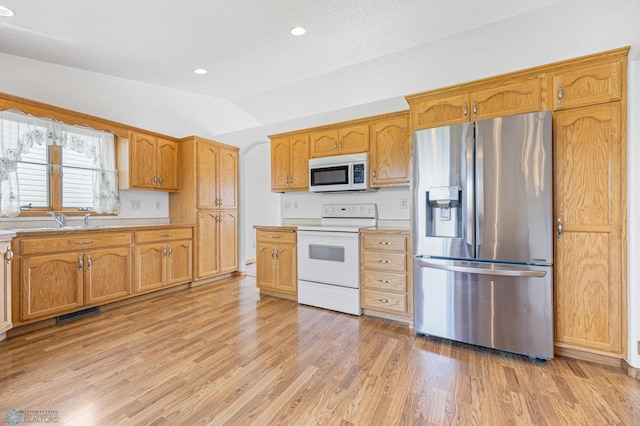 1878 10th St W, West Fargo, ND 58078 - kitchen featuring white appliances, lofted ceiling, light countertops, light wood-style floors, and a sink