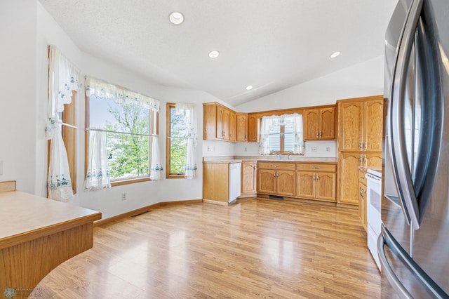 1878 10th St W, West Fargo, ND 58078 - kitchen featuring white appliances, plenty of natural light, light countertops, light wood finished floors, and lofted ceiling
