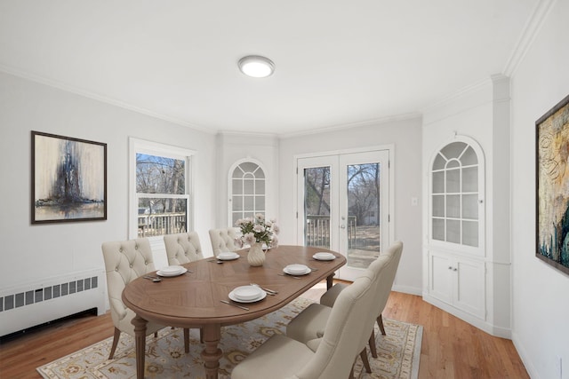 401 21st St SW, Austin, MN 55912 - dining area with radiator heating unit, ornamental molding, light wood-style floors, and healthy amount of natural light