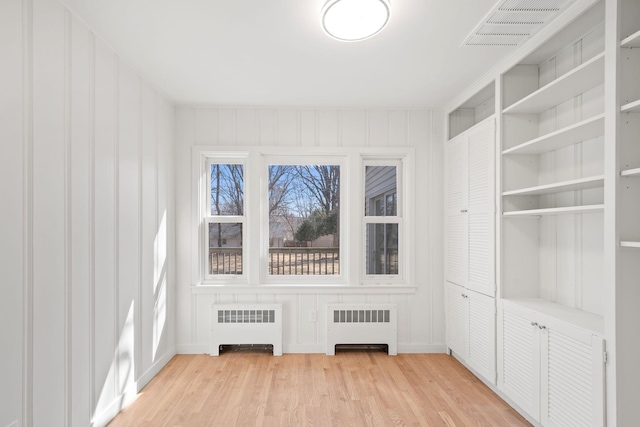 401 21st St SW, Austin, MN 55912 - spare room featuring radiator and light wood-style floors