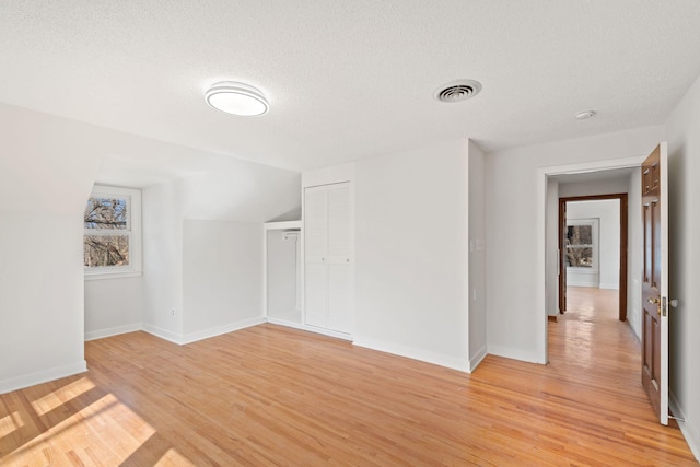 401 21st St SW, Austin, MN 55912 - spare room featuring a textured ceiling, light wood-style floors, and baseboards