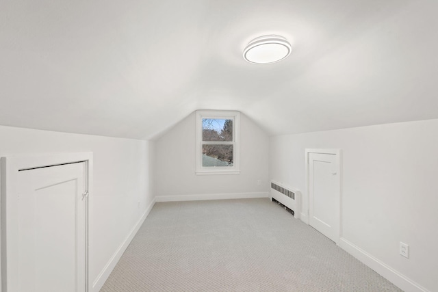 401 21st St SW, Austin, MN 55912 - additional living space featuring radiator heating unit, lofted ceiling, baseboards, and light colored carpet