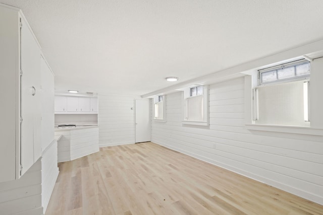 401 21st St SW, Austin, MN 55912 - unfurnished living room with light wood-type flooring and wooden walls