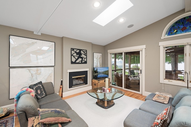 475 Lakeview Ave, Tonka Bay, MN 55331 - living area with wood finished floors, vaulted ceiling, a skylight, a glass covered fireplace, and recessed lighting