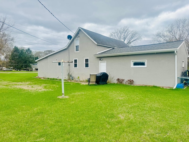 802 5th St NE, Little Falls, MN 56345 - back of house featuring a yard, stucco siding, and roof with shingles