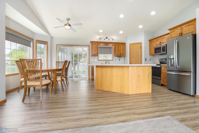 509 32nd St N, Moorhead, MN 56560 - kitchen with appliances with stainless steel finishes, light countertops, light wood-type flooring, vaulted ceiling, and ceiling fan