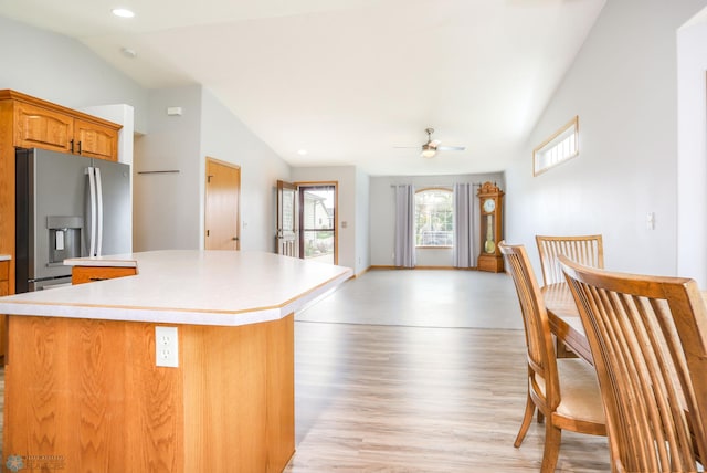 509 32nd St N, Moorhead, MN 56560 - kitchen featuring vaulted ceiling, stainless steel refrigerator with ice dispenser, a center island, light countertops, and light wood finished floors
