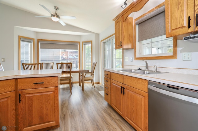 509 32nd St N, Moorhead, MN 56560 - kitchen featuring dishwasher, a sink, vaulted ceiling, light countertops, and light wood-type flooring