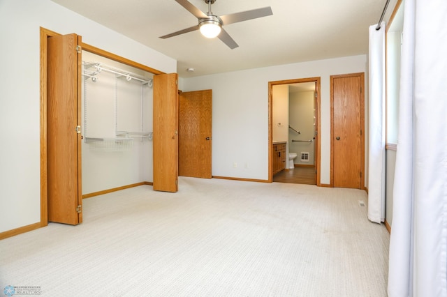509 32nd St N, Moorhead, MN 56560 - unfurnished bedroom with a closet, baseboards, carpet flooring, ceiling fan, and connected bathroom
