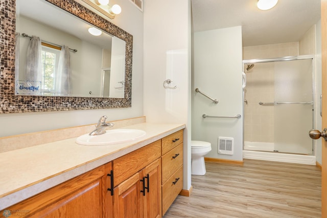 509 32nd St N, Moorhead, MN 56560 - full bath featuring toilet, a stall shower, vanity, and wood finished floors