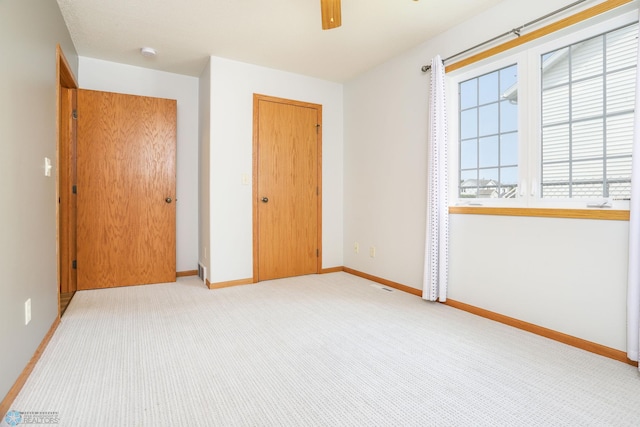 509 32nd St N, Moorhead, MN 56560 - unfurnished bedroom with baseboards, a closet, a ceiling fan, and carpet floors