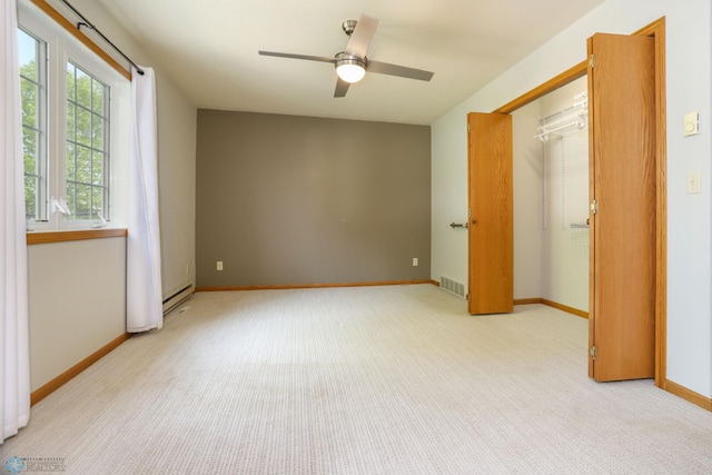 509 32nd St N, Moorhead, MN 56560 - unfurnished bedroom with a baseboard heating unit, light colored carpet, a closet, baseboards, and ceiling fan