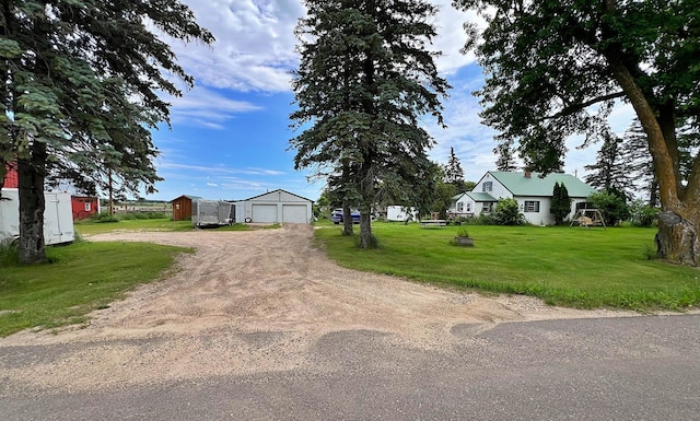 49892 285th Ave, Staples, MN 56479 - view of front facade with an outdoor structure, driveway, a front lawn, and a detached garage