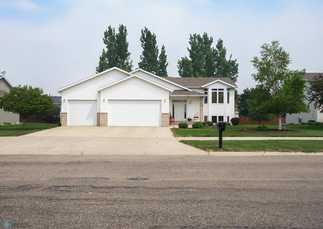 1010 4th Ave NE, Dilworth, MN 56529 - split level home with an attached garage, concrete driveway, a front lawn, and brick siding