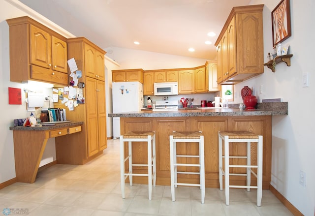 1010 4th Ave NE, Dilworth, MN 56529 - kitchen with white appliances, a peninsula, lofted ceiling, a kitchen bar, and baseboards