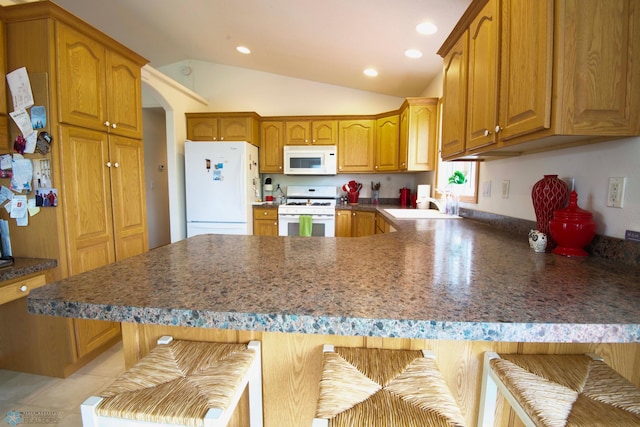 1010 4th Ave NE, Dilworth, MN 56529 - kitchen featuring white appliances, a peninsula, a kitchen breakfast bar, a sink, and brown cabinets