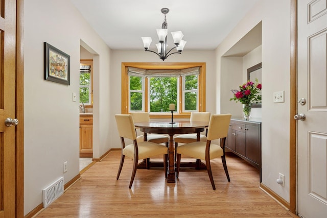 3933 Dartmouth Dr, Minnetonka, MN 55345 - dining space with light wood-style flooring, a chandelier, and baseboards