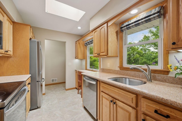 3933 Dartmouth Dr, Minnetonka, MN 55345 - kitchen featuring appliances with stainless steel finishes, a skylight, light stone counters, recessed lighting, and light tile patterned flooring