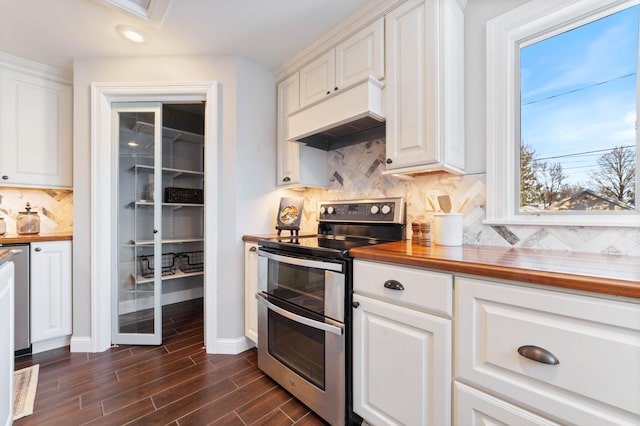 405 7th St S, Virginia, MN 55792 - kitchen featuring range with two ovens, butcher block counters, white cabinets, tasteful backsplash, and custom exhaust hood